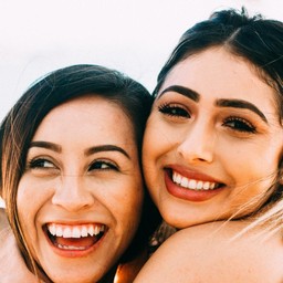 Two young women hugging and smiling.