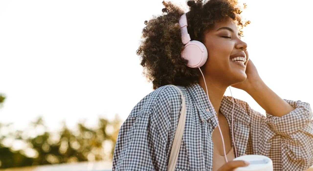 Woman with headphones on listening to music outside